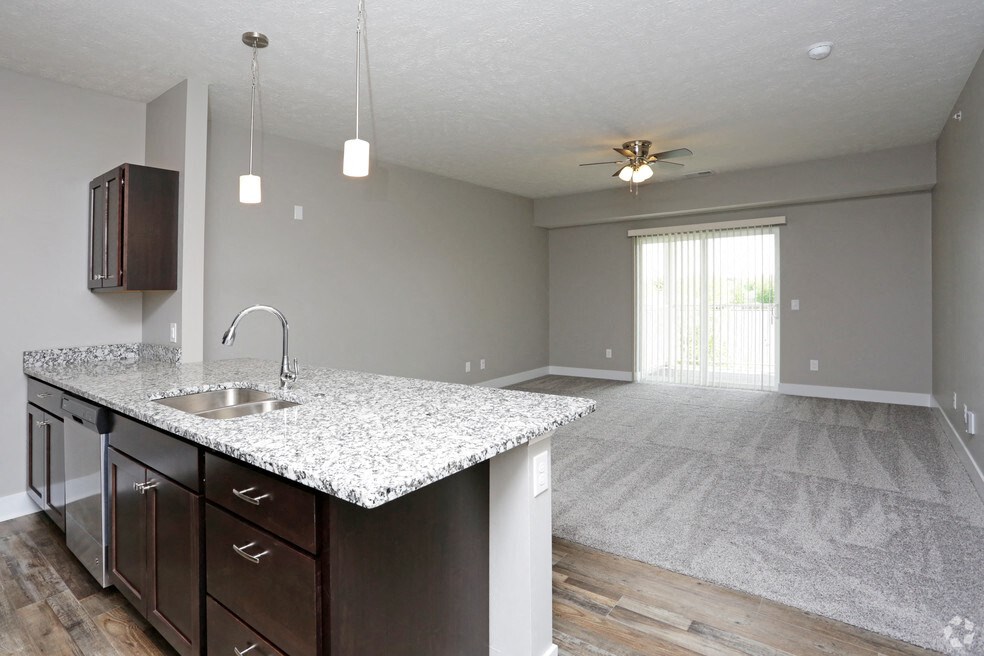 an empty kitchen and living room with a granite counter top