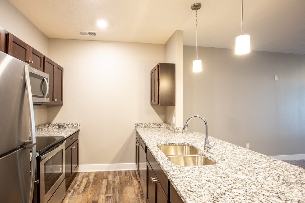 a kitchen with granite counter tops and stainless steel appliances