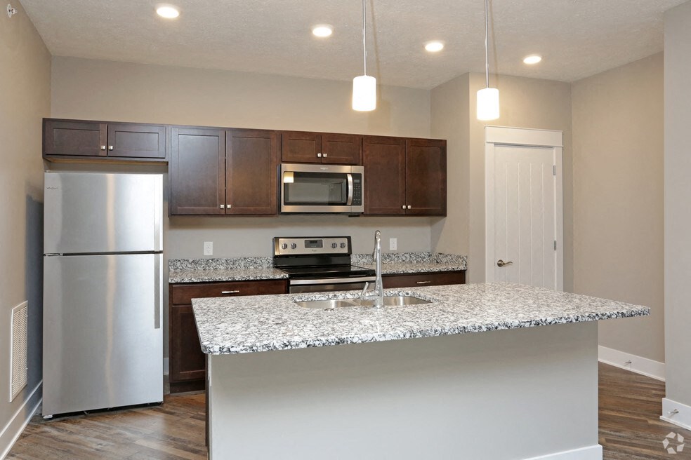 a kitchen with a granite counter top and stainless steel refrigerator