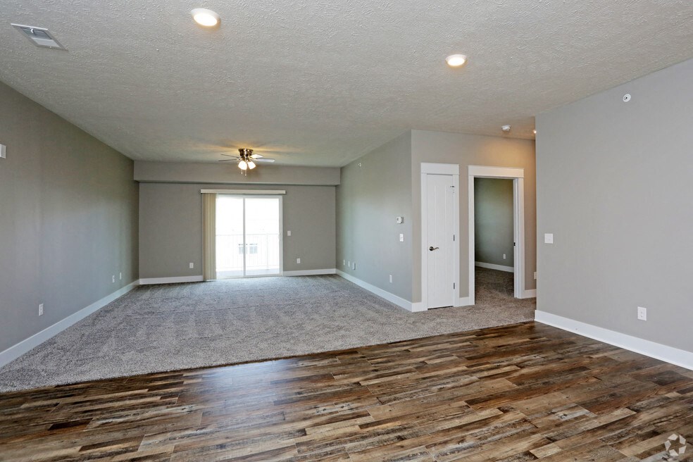 the living room and dining room of an empty home with wood flooring