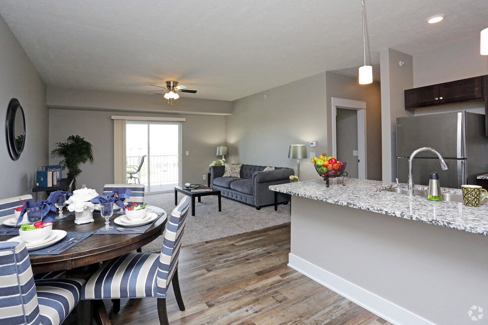 a living room and dining room with a table and chairs