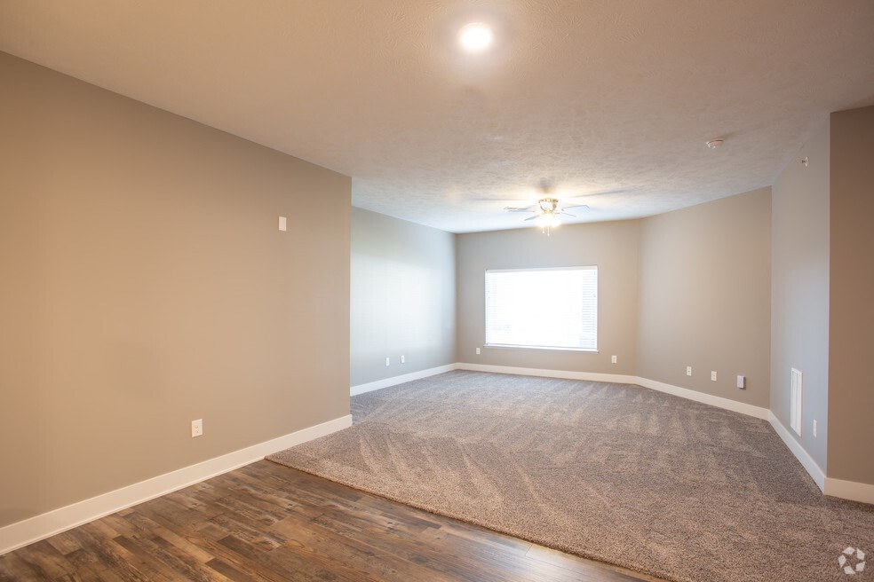 an empty living room with wood flooring and a window
