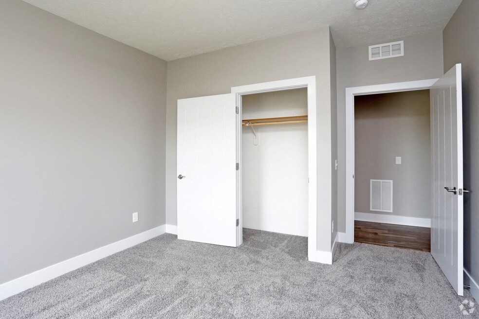 an empty bedroom with a closet and a door to a closet