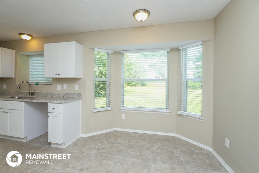 a kitchen with white cabinets and a sink and a window