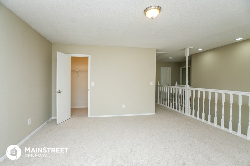 the upstairs living room and hallway of an empty house