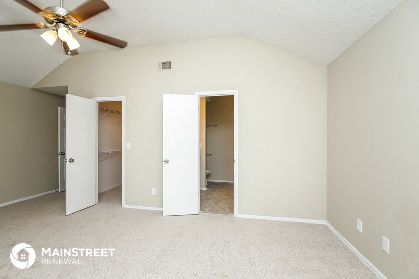 a master bedroom with a ceiling fan and a closet