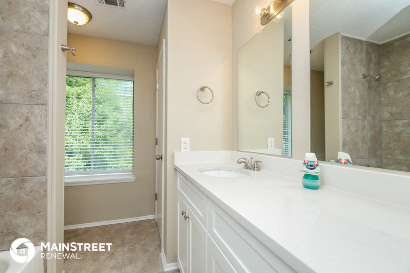 the master bathroom has a large mirror and a large sink