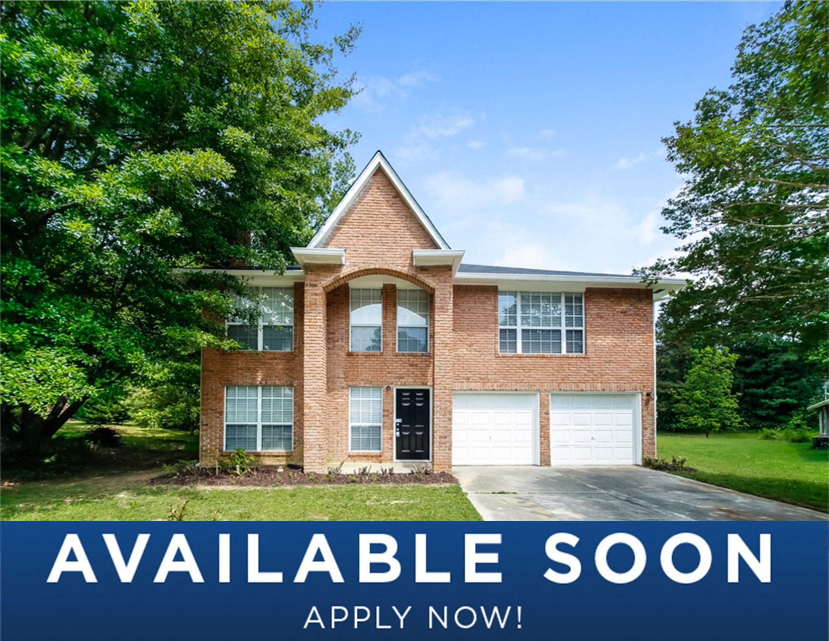 a large brick house with a lawn and trees