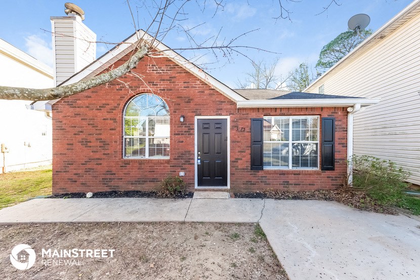 the front of a brick house with a black door