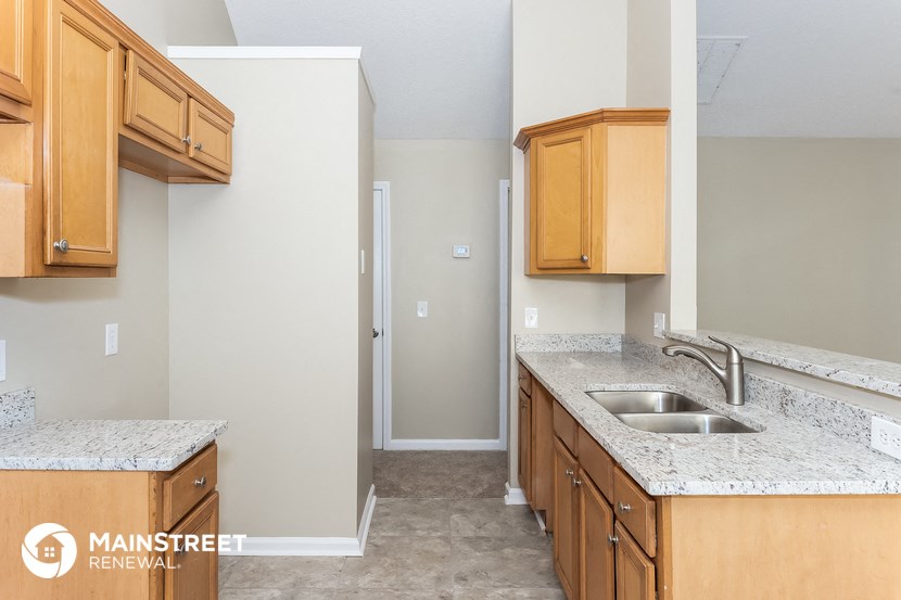 a kitchen with wooden cabinets and granite counter tops and a sink