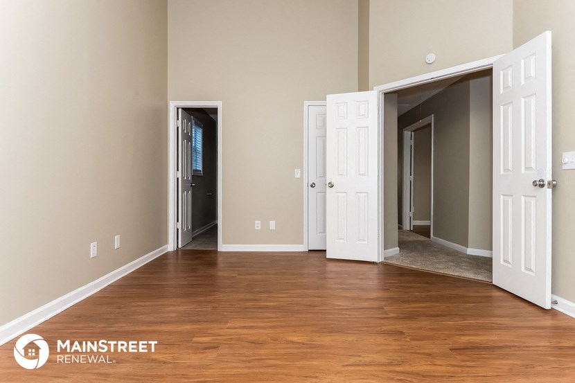 a living room with a wood floor and three doors