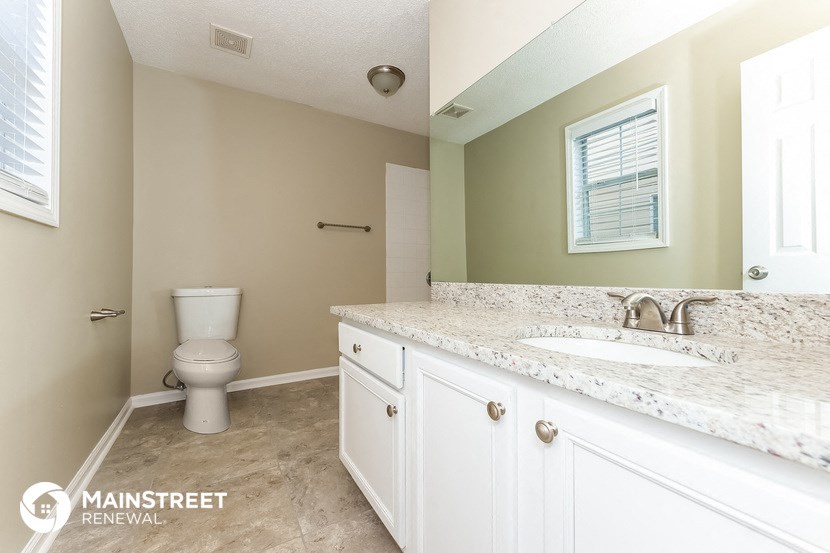 a bathroom with a toilet and a sink and a mirror