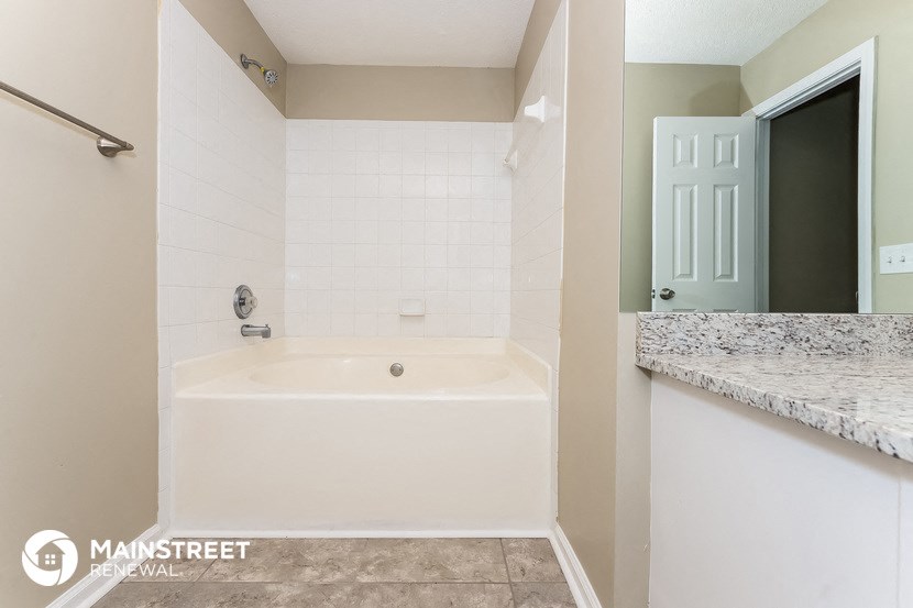 the master bathroom has a soaking tub and a door to the closet