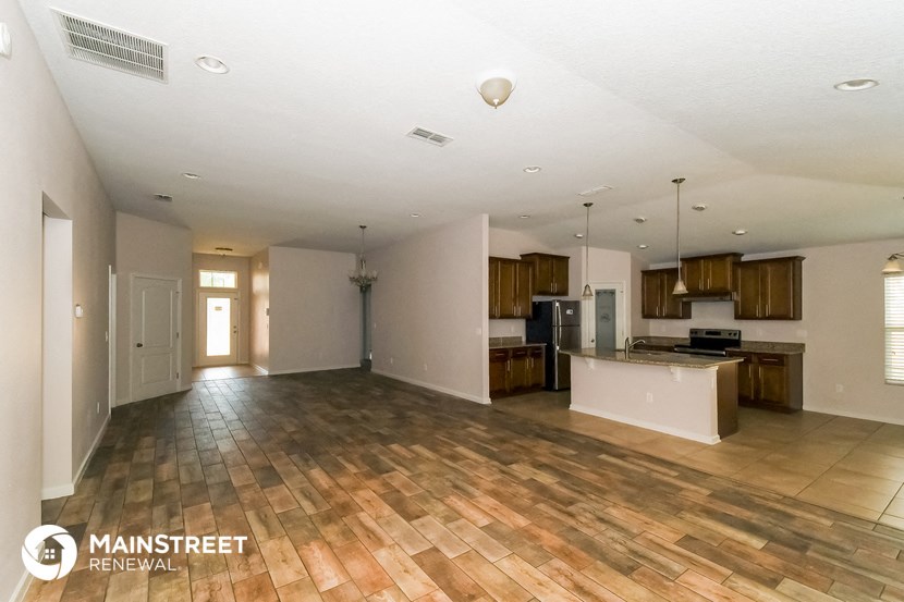 an open kitchen and living room with wood flooring