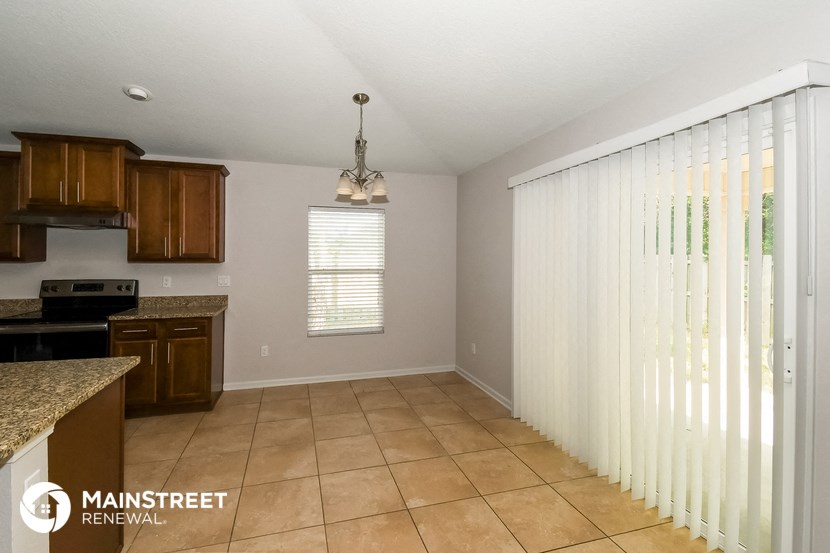 an empty kitchen with white blinds on the window