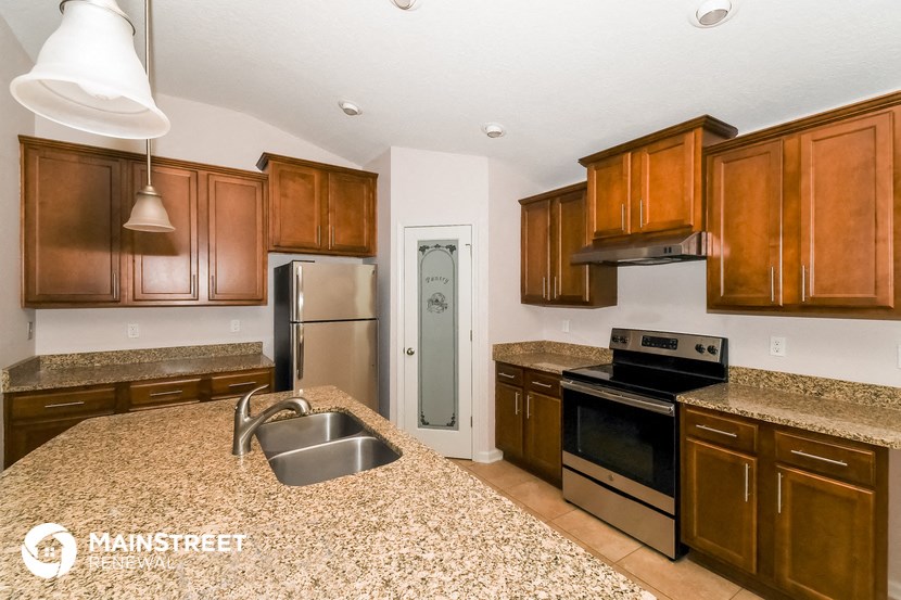 a kitchen with granite counter tops and wooden cabinets