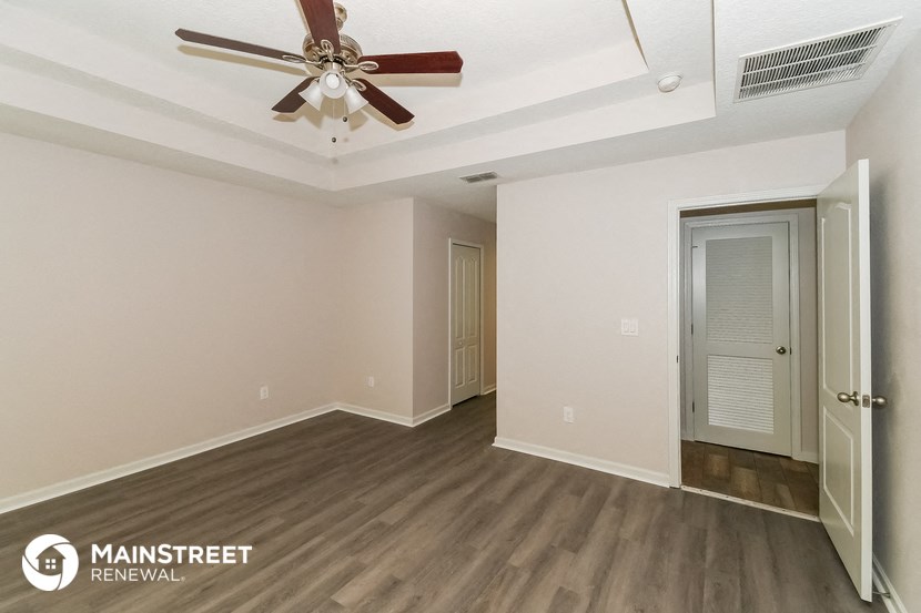 a living room with a ceiling fan and wood flooring