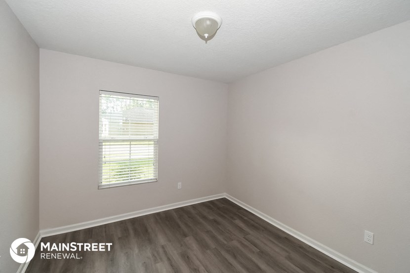 the interior of an empty room with wooden floors and a window