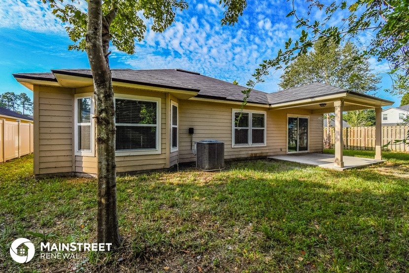 the exterior of a yellow house with a yard and trees