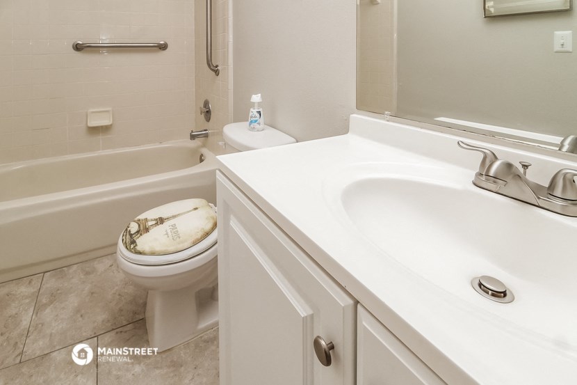 a bathroom with a toilet and a sink and a bath tub