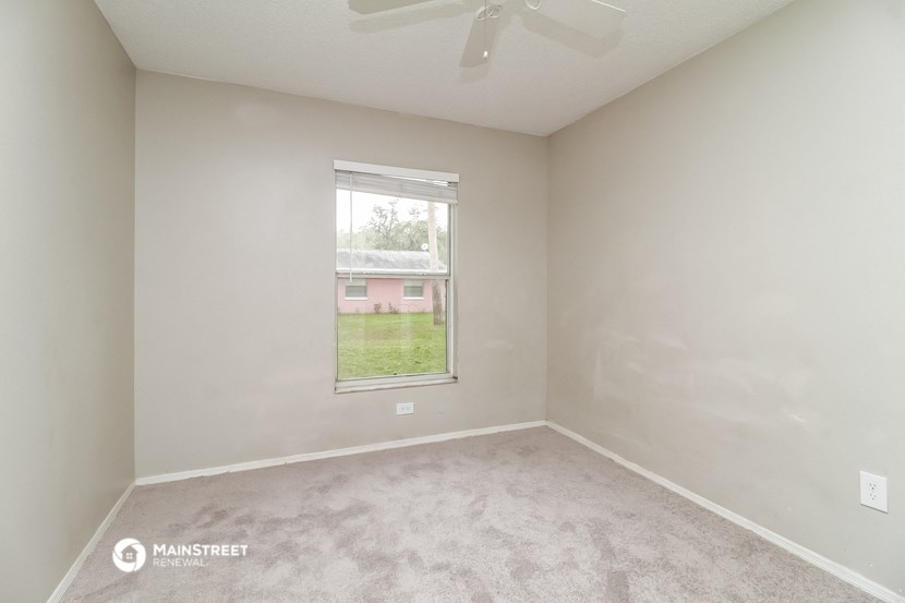 an empty room with a window and carpet