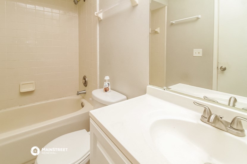 a bathroom with a sink toilet and tub and a mirror