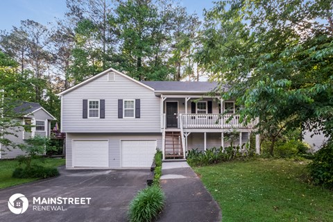 a white house with a white garage door and a porch