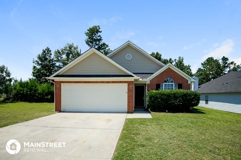 a home with a garage door and a lawn