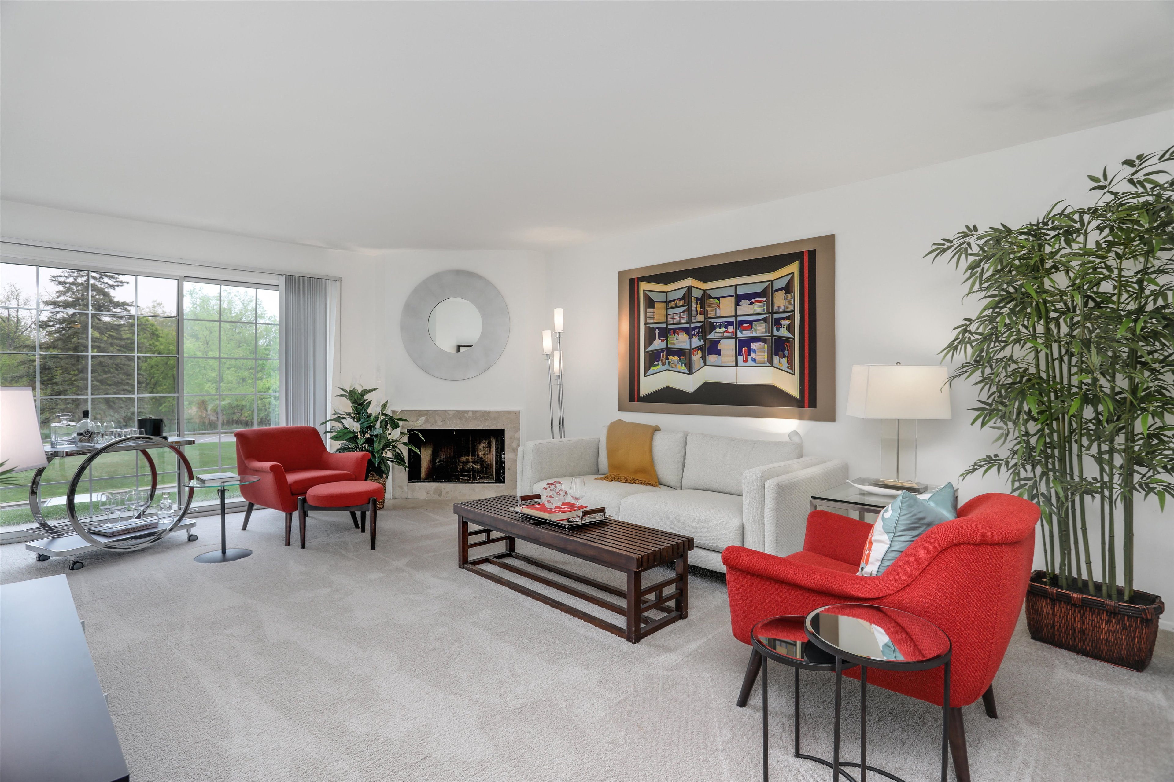 A living room with a red chair and a white couch.