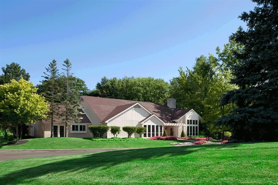 a white house with a lawn and trees
