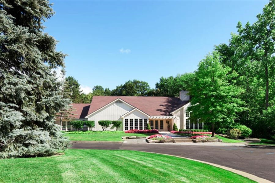 a large white house with a lawn and trees