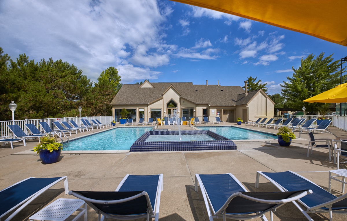 our resort style pool with lounge chairs and a building in the background