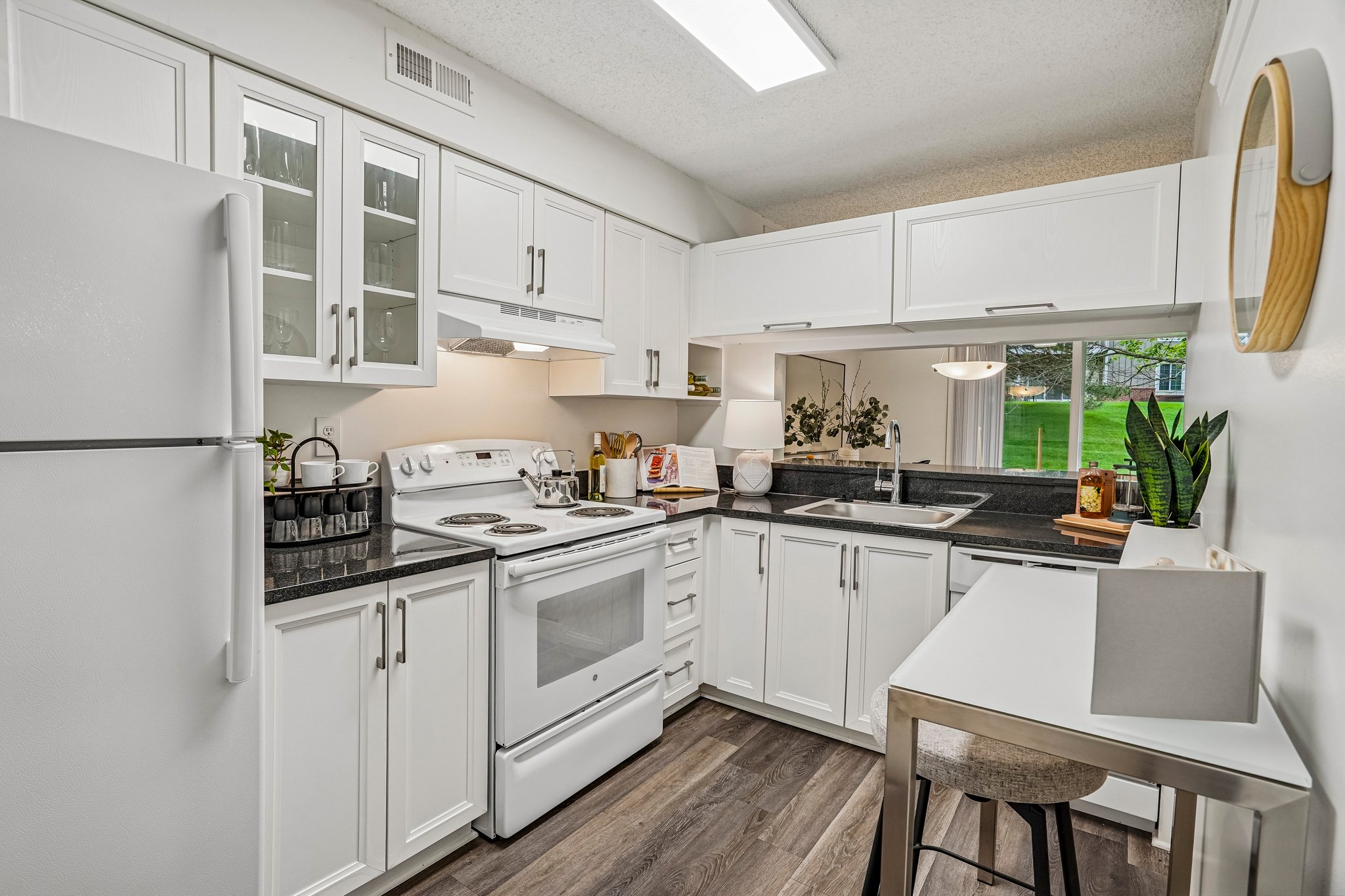 A kitchen with white cabinets and appliances.