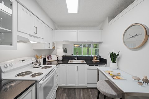 A modern kitchen with white cabinets and a black countertop.
