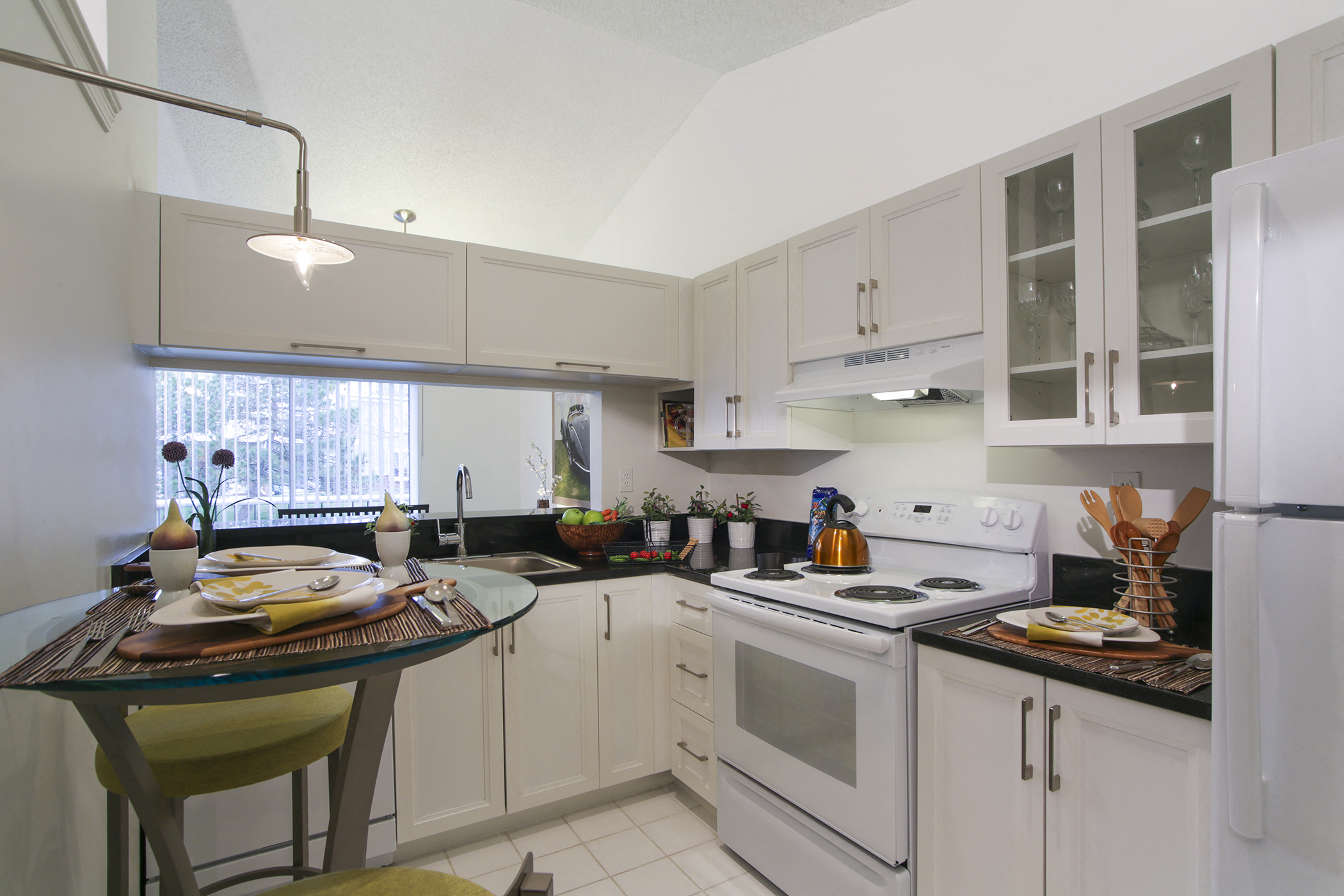a kitchen with white appliances and white cabinets and a table