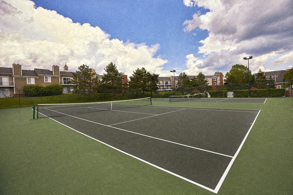 a tennis court with apartments in the background