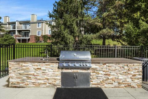 a barbecue grill on top of a stone wall