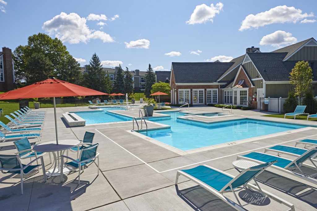 our apartments have a large swimming pool with chairs and umbrellas