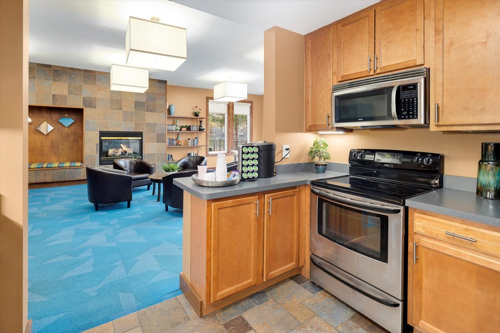 a kitchen and living room with a stove and a microwave
