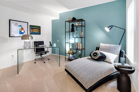 a bedroom with a bed and a desk with a computer