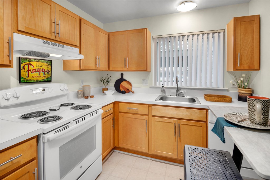 a kitchen with white appliances and wooden cabinets