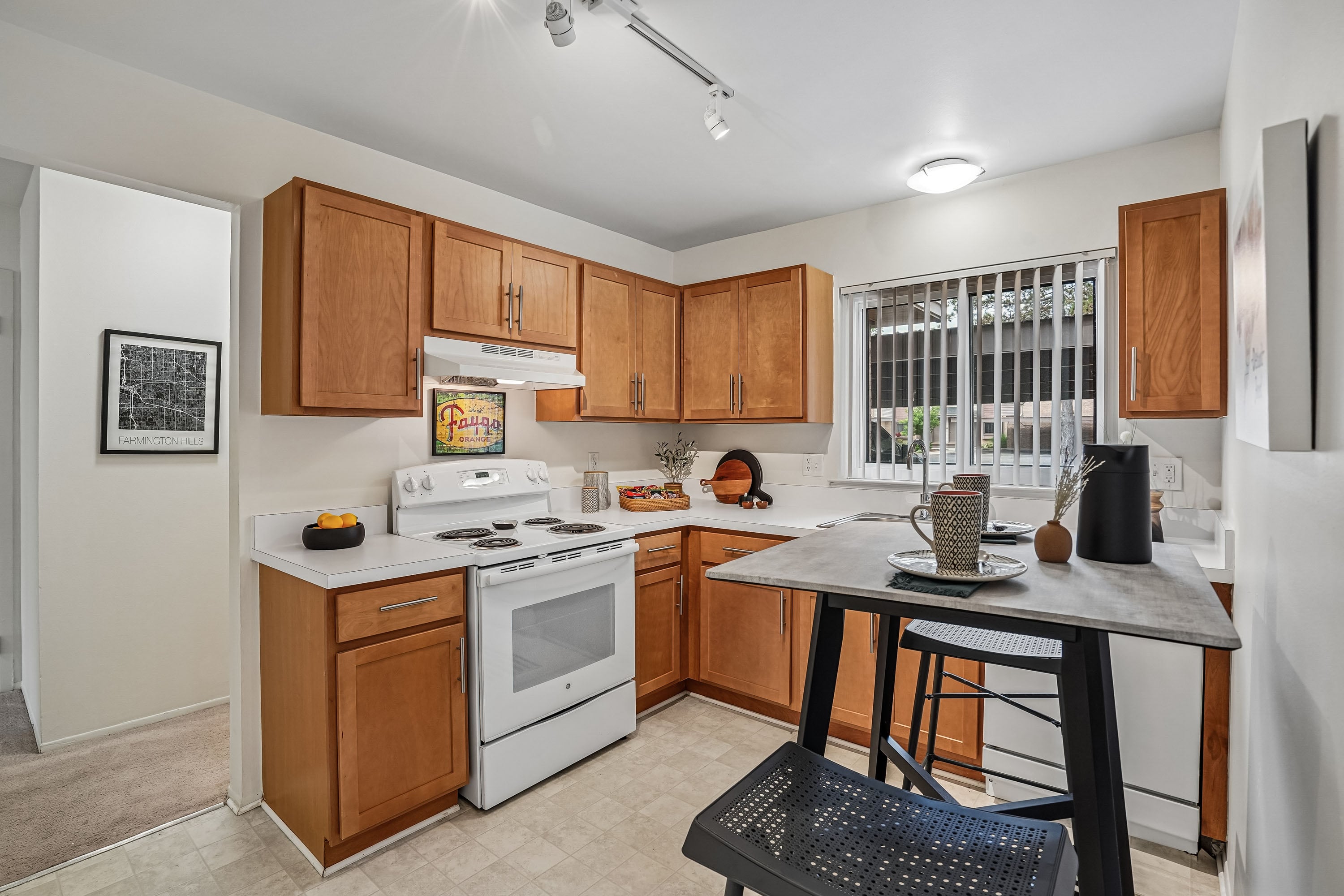 A kitchen with wooden cabinets and a white stove top oven.