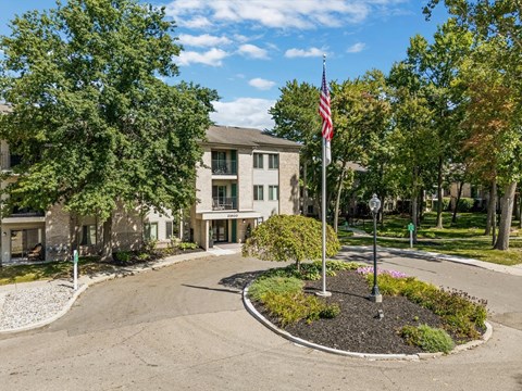 the roundabout in front of a building with an flag on a pole