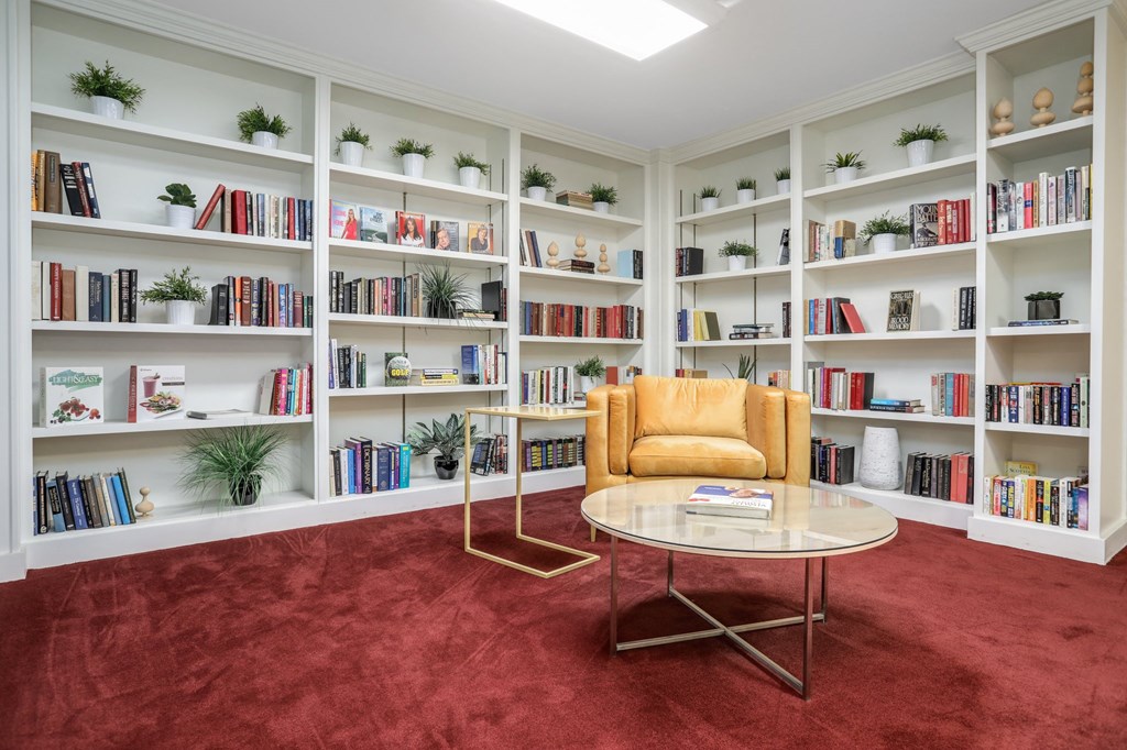 a room with a bookshelf and a chair and a table