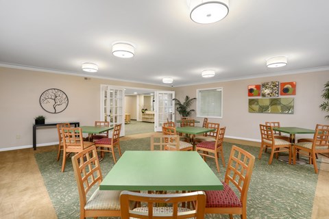 a community room with tables and chairs and a green table