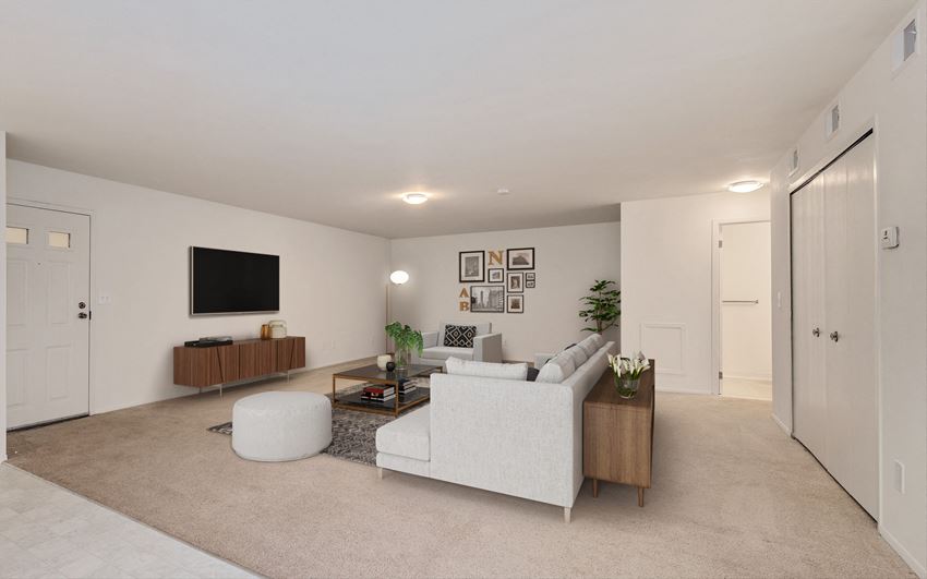a living room with white walls and beige carpet