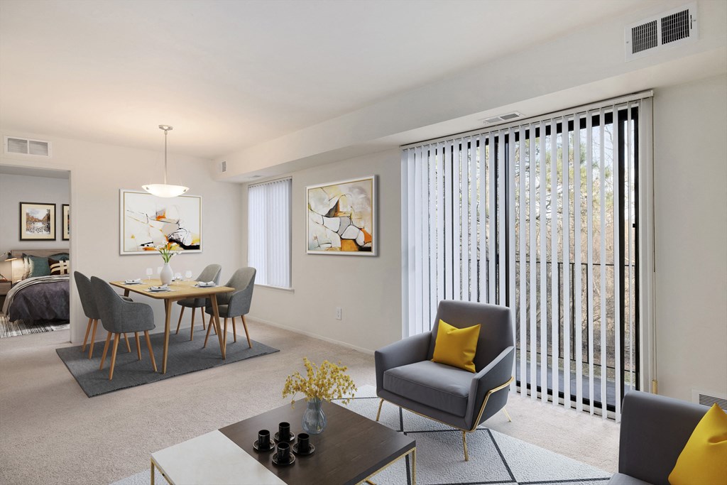 the living room and dining room of an apartment with a table and chairs