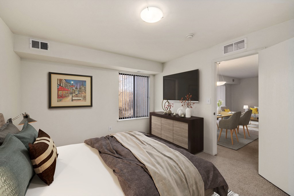 a bedroom with a bed and a tv and a living room