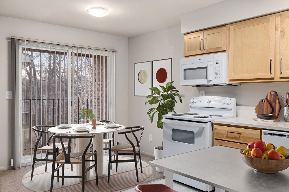 A kitchen with a table and chairs in front of a window.