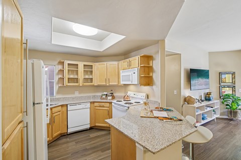 A kitchen with wooden cabinets and a granite countertop.